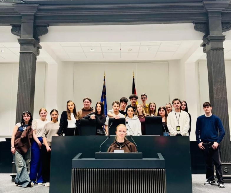 Schülergruppe in einem parlamentarischen Saal. 