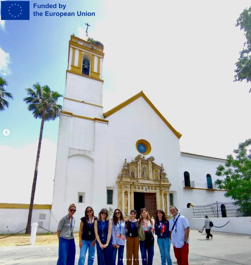 Schüler stehen vor einer südländisch anmutenden Kirche. Oben links steht: ‘Funded by the European Union’ mit EU-Flagge.