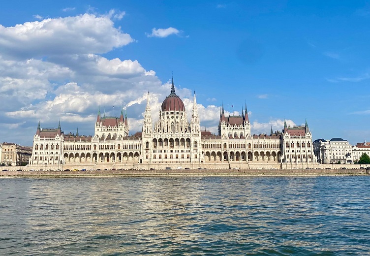 Eine prachtvoll anmutende Kathedrale in der Sonne, vor einem See, oder Fluss. 